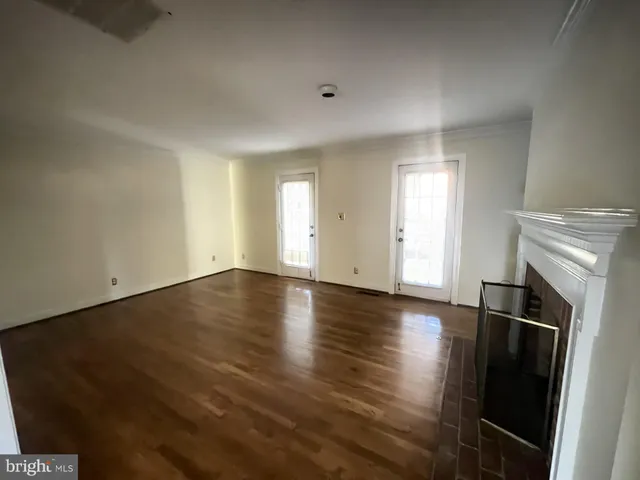 an empty room with wooden floor and fireplace