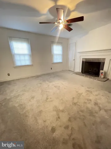 an empty room with windows and fireplace