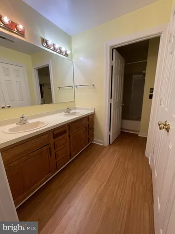 a spacious bathroom with a double vanity sink and mirror