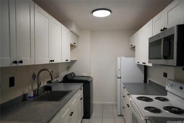 a kitchen with stainless steel appliances a sink a stove and a refrigerator with wooden floor