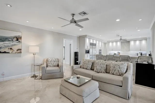 a kitchen with stainless steel appliances kitchen island granite countertop a dining table chairs and a refrigerator