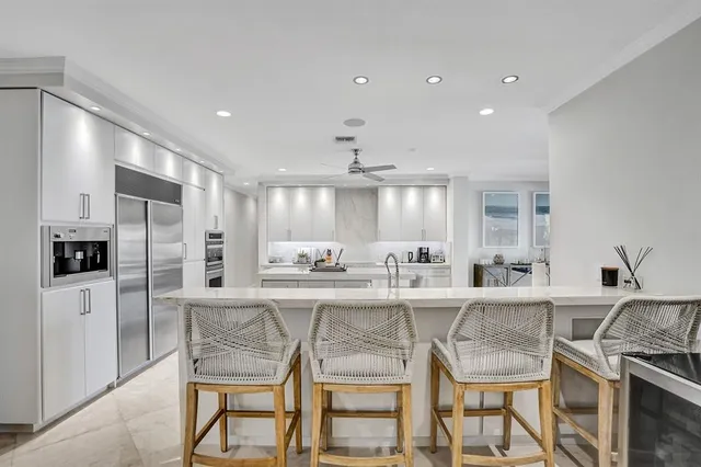 a dining room with furniture large windows and outdoor view