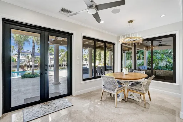 a bedroom with a large bed a chandelier with dresser and mirror
