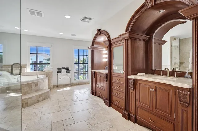 a bedroom with a large bed a chandelier and windows