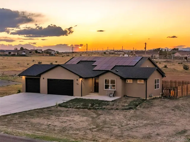 a view of a large house with a big yard and large tree