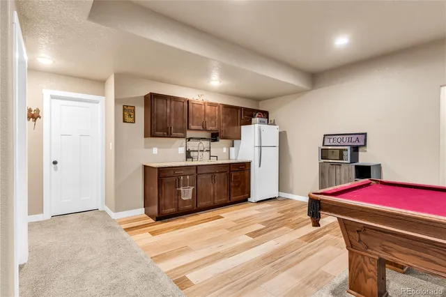 a kitchen with stainless steel appliances kitchen island granite countertop a refrigerator and a sink