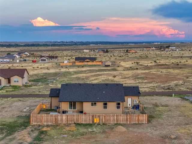 a view of a dry yard with wooden fence