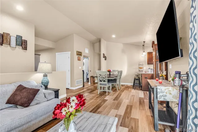a living room with furniture wooden floor and a flat screen tv