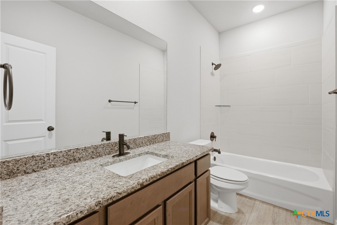 3201 Hedwig Street Killeen, TX 76549 - Photo 24 of 38 a bathroom with a granite countertop sink a toilet and a bathtub