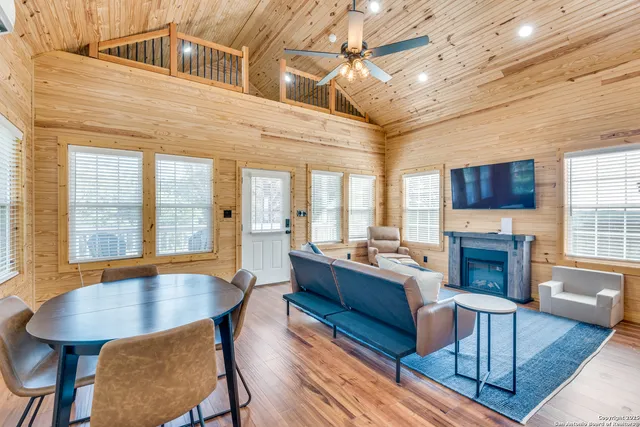 a living room with fireplace furniture flat screen tv and windows