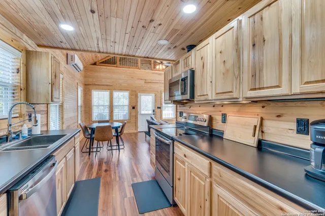 a kitchen with stainless steel appliances granite countertop a sink stove and cabinets