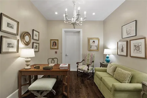 a living room with furniture a chandelier and a dining table
