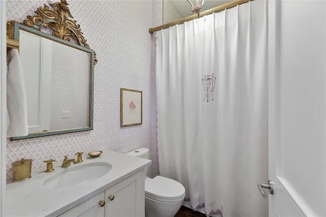 a bathroom with a sink a toilet and shower curtain