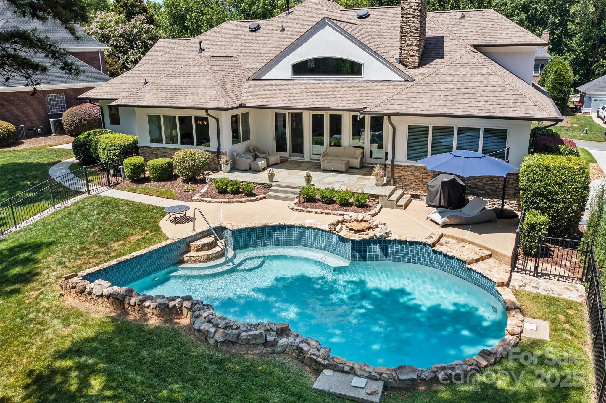 a view of a house with backyard swimming pool and sitting area