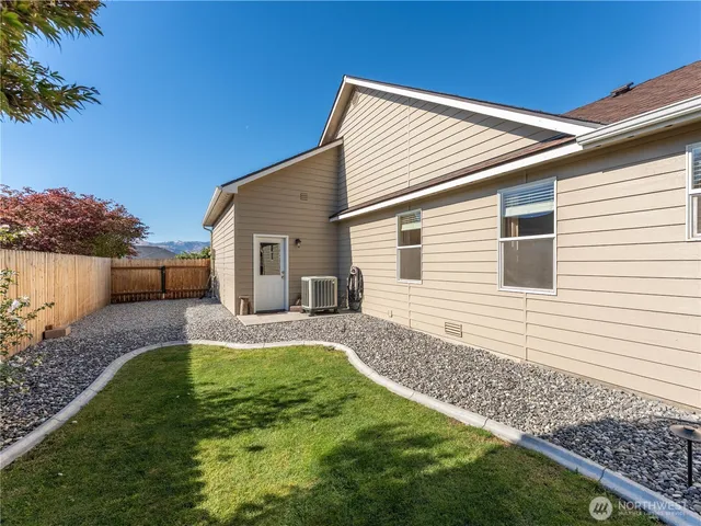 a view of a backyard with plants and large tree