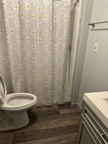 a toilet sitting in a bathroom next to a wooden wall