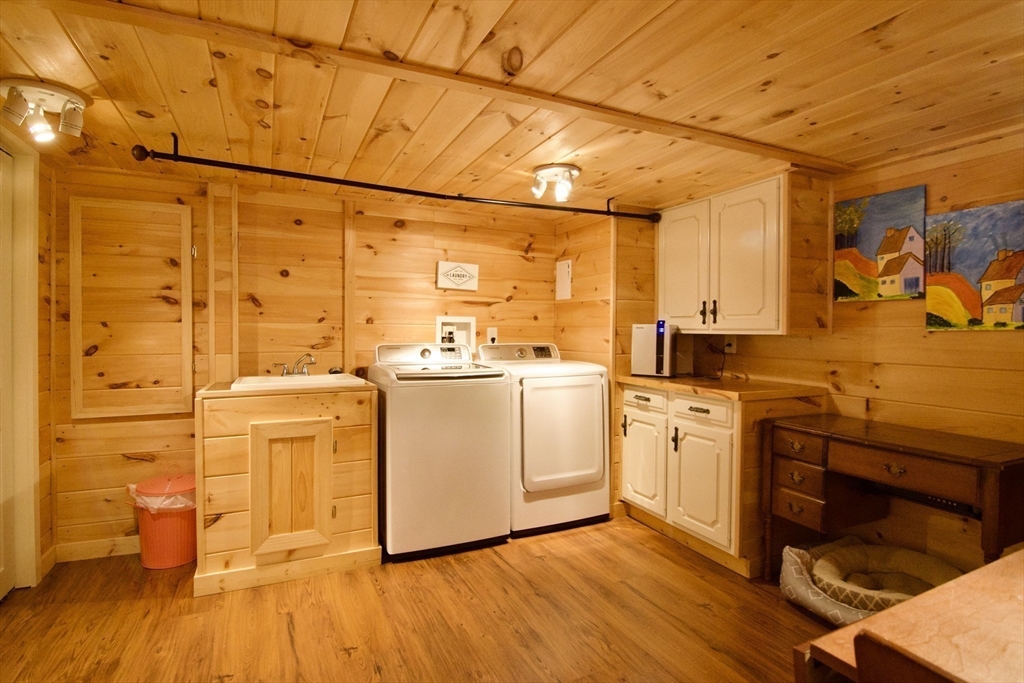 1070 Plumtree Road Springfield, MA 01119 - Photo 33 of 40 a kitchen with stainless steel appliances a stove a sink and white cabinets with wooden floor