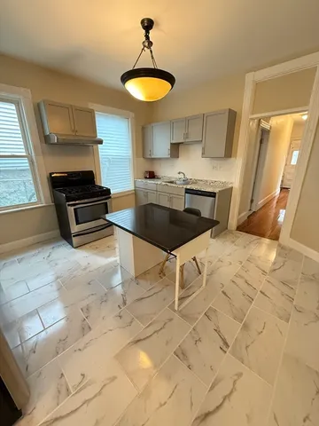 a kitchen with granite countertop a stove a sink and a granite counter top