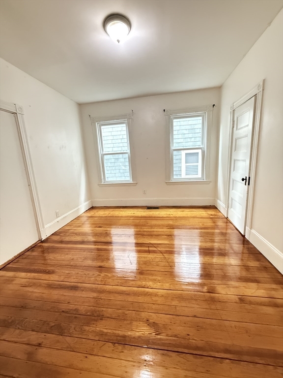 10 Bucknam Street, Unit 1 (NOW) Boston, MA 02120 - Photo 6 of 8 an empty room with wooden floor and windows