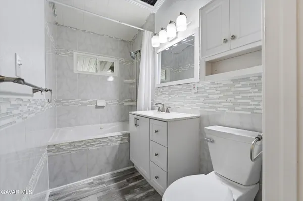 a bathroom with a sink a toilet and mirror