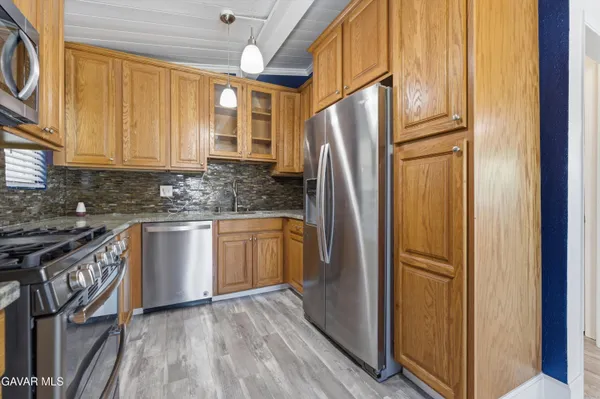 a kitchen with granite countertop a refrigerator and a sink