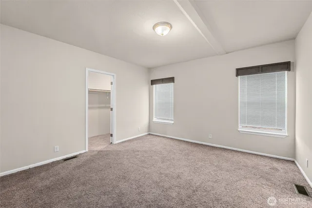 an empty room with windows and closet