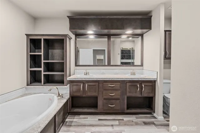a spacious bathroom with a tub and a double vanity sink