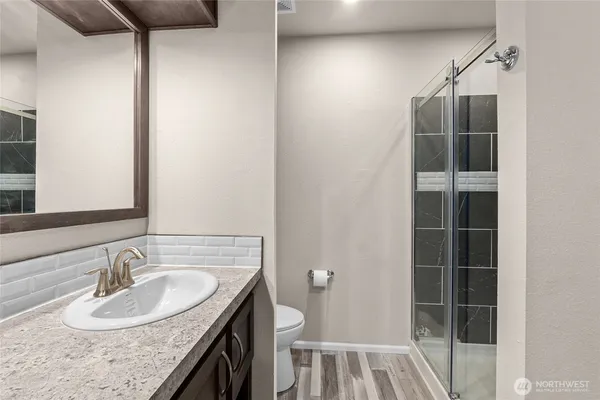 a bathroom with a granite countertop sink and a mirror