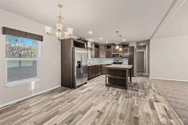 a kitchen with stainless steel appliances kitchen island granite countertop a refrigerator and a stove top oven