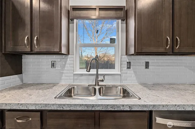 a kitchen with granite countertop a sink and a stove