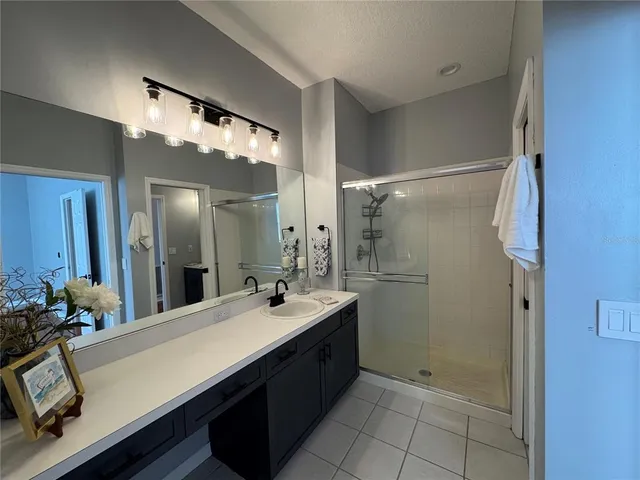a bathroom with a double vanity sink mirror and shower