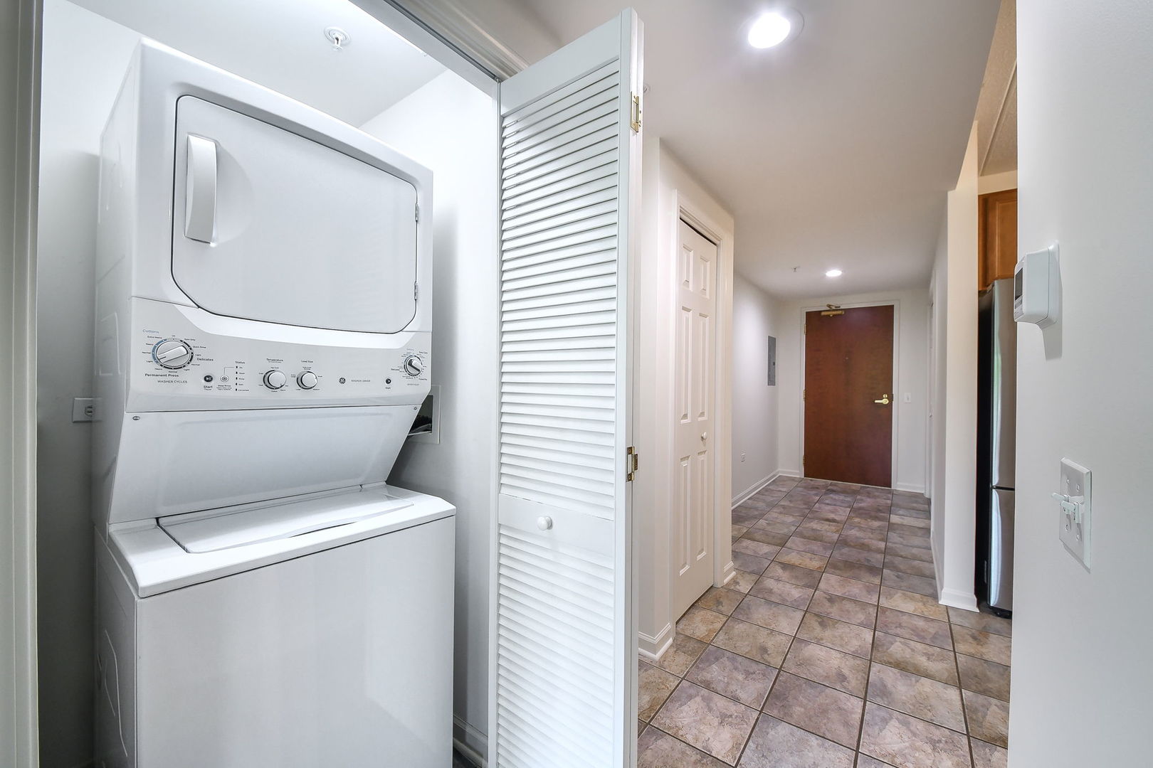 586 Crescent Boulevard, Unit 305 Glen Ellyn, IL 60137 - Photo 12 of 13 a view of a hallway with washer and dryer