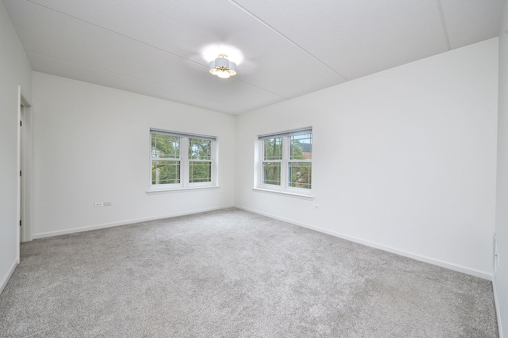 586 Crescent Boulevard, Unit 305 Glen Ellyn, IL 60137 - Photo 9 of 13 an empty room with windows