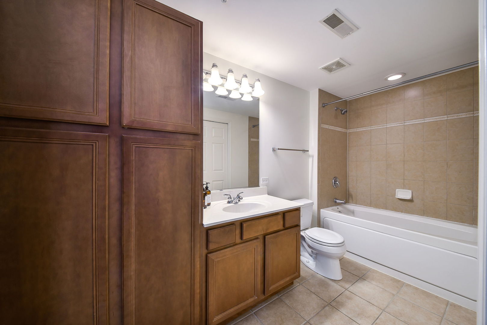 586 Crescent Boulevard, Unit 305 Glen Ellyn, IL 60137 - Photo 10 of 13 a bathroom with a sink a toilet and shower