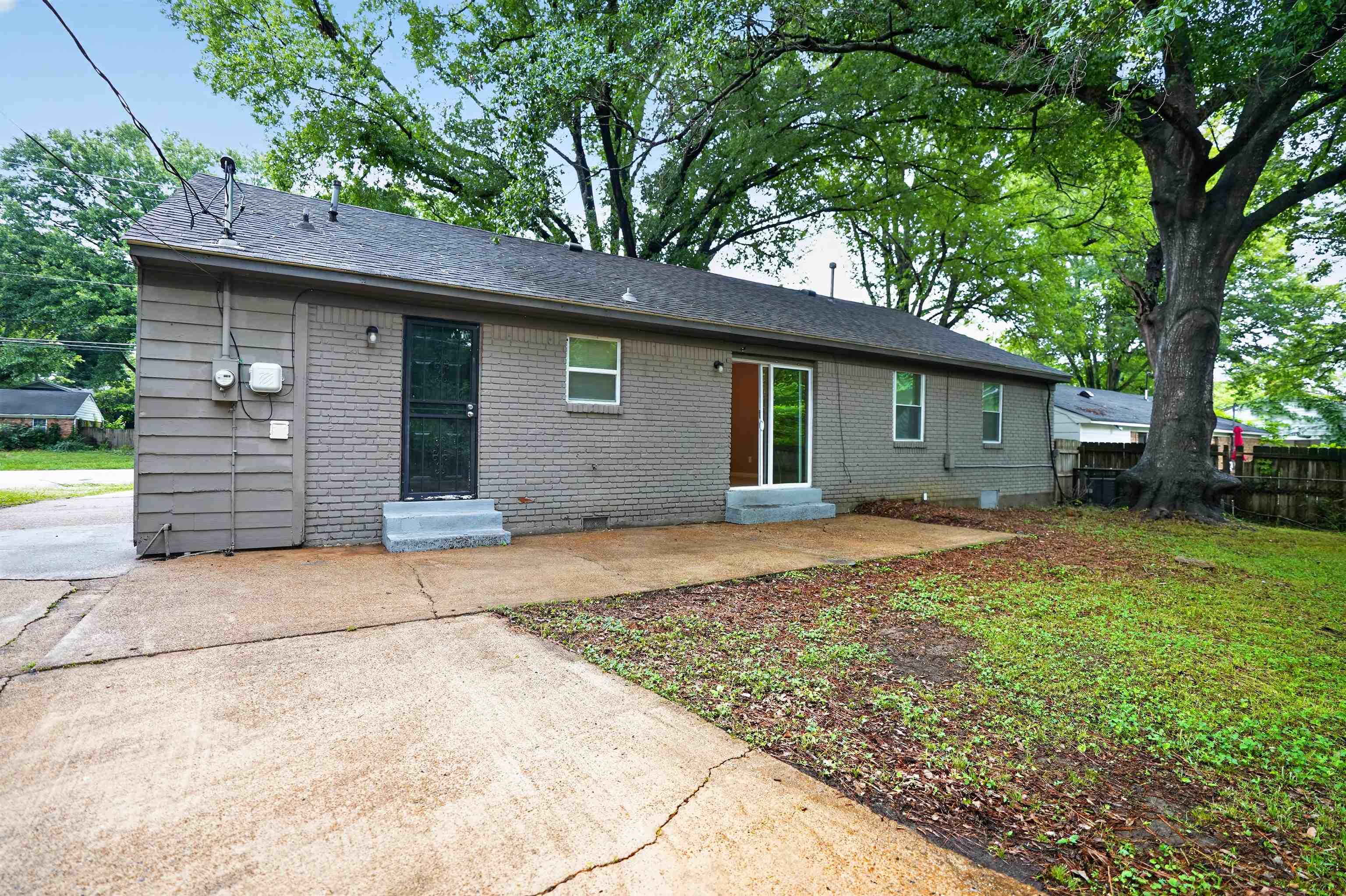 4191 Yale Road Memphis, TN 38128 - Photo 22 of 22 Rear exterior with brick and siding facade, concrete patio, and mature trees