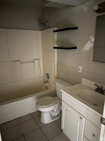 874 770 South Tooele, UT 84074 - Photo 15 of 19 Bathroom featuring a white vanity with integrated sink, a matching white toilet, and a white bathtub with a shower head
