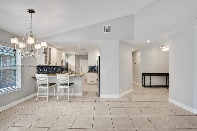 a kitchen with stainless steel appliances kitchen island granite countertop a refrigerator and a sink