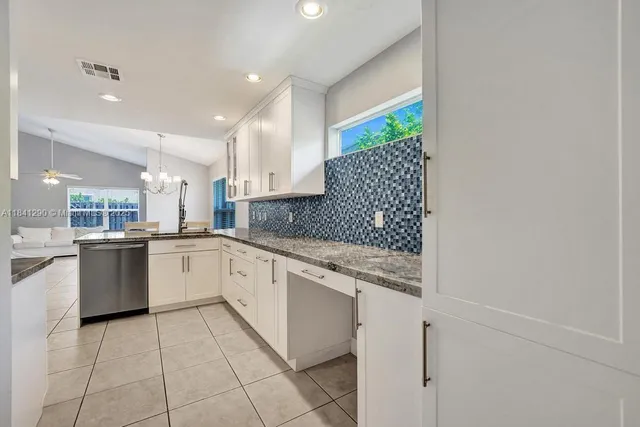 a large white kitchen with a sink and cabinets