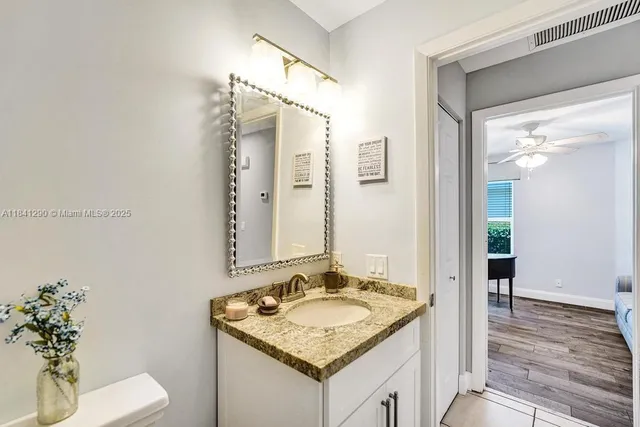 a bathroom with a granite countertop sink and a mirror