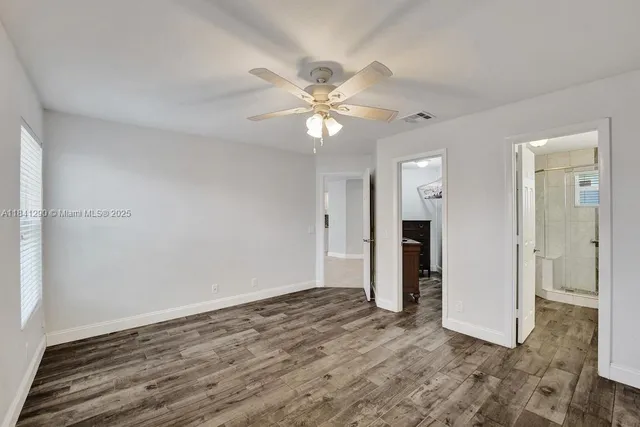 an empty room with closet and a chandelier fan
