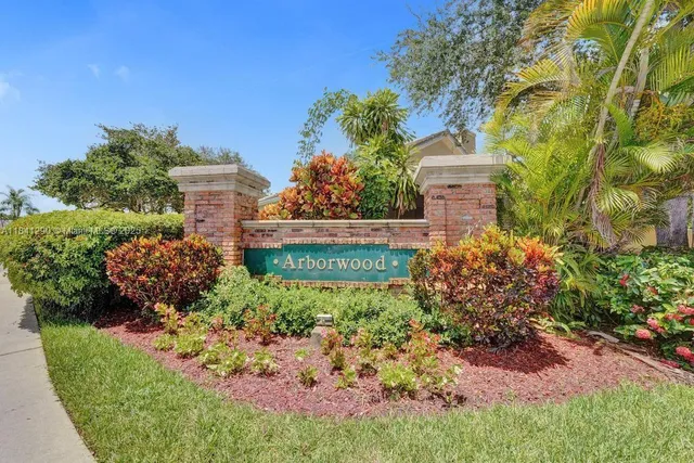 a view of a garden with plants and large trees