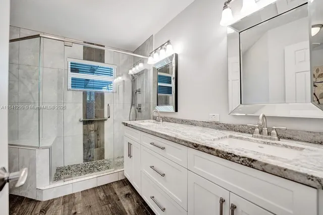 a bathroom with a granite countertop sink and a mirror