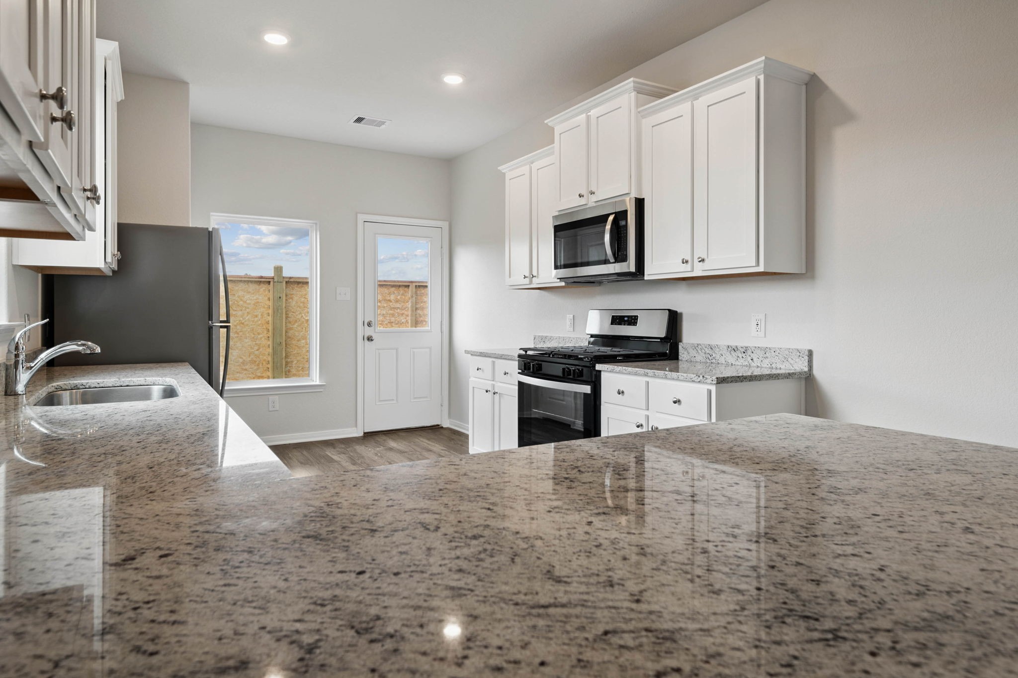 15434 Maple Ter Drive Conroe, TX 77303 - Photo 6 of 25 a kitchen with granite countertop a sink a stove and cabinets