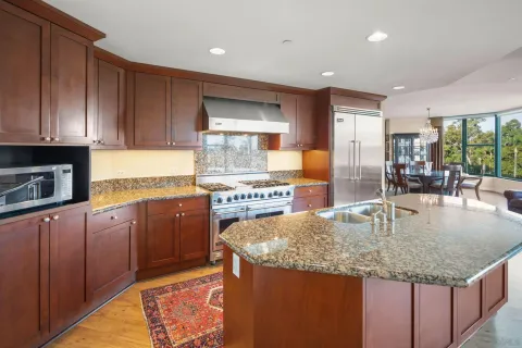 a kitchen with granite countertop a sink a counter top space appliances and cabinets