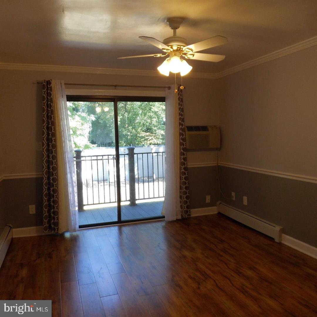 2848 Annandale Road, Unit 124 Falls Church, VA 22042 - Photo 2 of 8 a view of an empty room with wooden floor and a window
