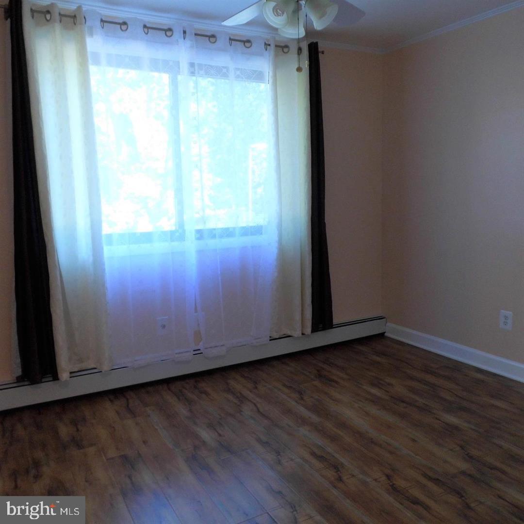 2848 Annandale Road, Unit 124 Falls Church, VA 22042 - Photo 6 of 8 an empty room with wooden floor and windows