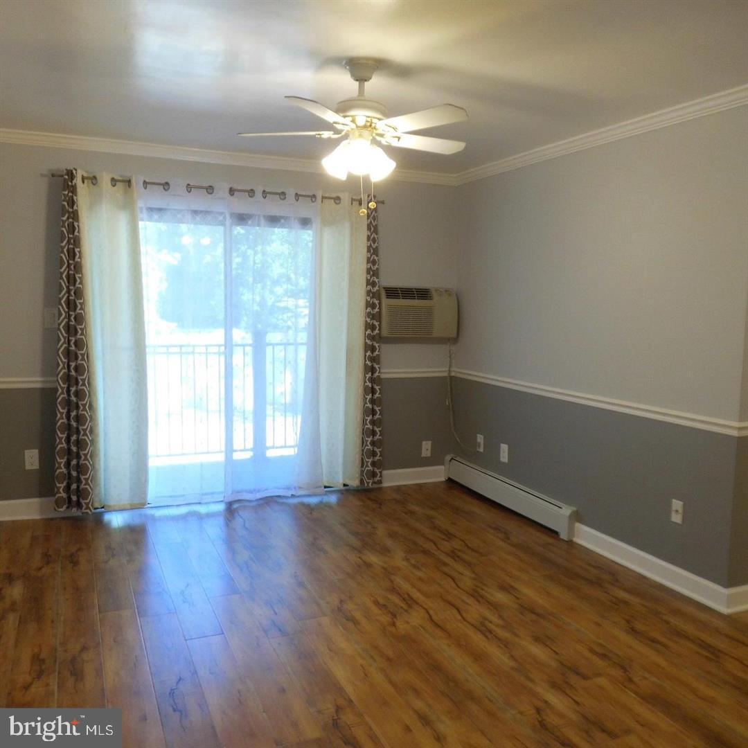 2848 Annandale Road, Unit 124 Falls Church, VA 22042 - Photo 8 of 8 a view of an empty room with a window and wooden floor