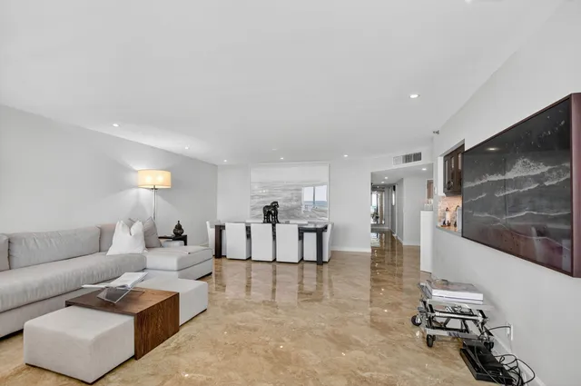 a dining hall with stainless steel appliances granite countertop a sink and a refrigerator