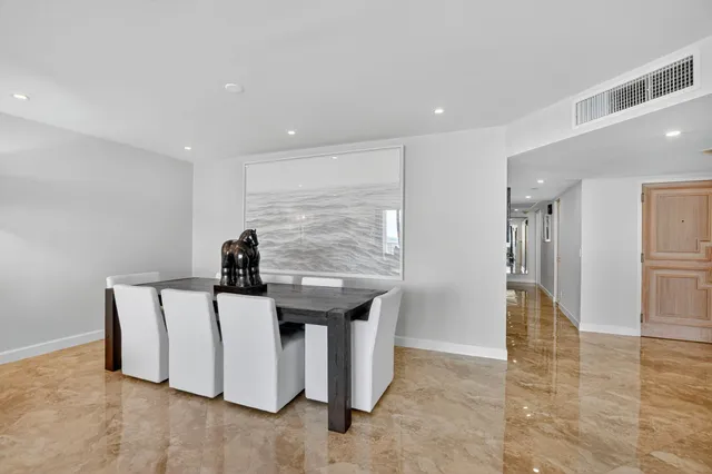 a kitchen with granite countertop a refrigerator and white cabinets