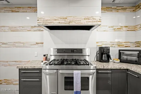 a kitchen with granite countertop a sink a stove and a granite counter tops